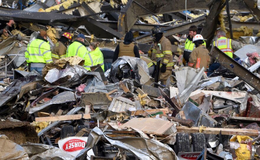 Emergency workers search what is left of the Mayfield Consumer Products Candle Factory on Saturday after it was destroyed in Mayfield, Ky.