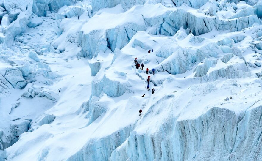 China will set up a "line of separation" at Mount Everest's summit, as Nepal struggles to control a COVID-19 outbreak. In this photograph, on May 2, 2021 mountaineers trek along the Khumbu glacier near Everest base camp in the Mount Everest region of Solukhumbu district, some 140 km northeast of Nepal's capital Kathmandu.