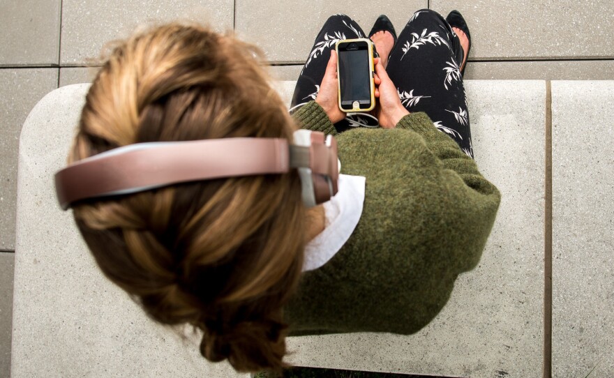 She's not tuning in, she's tuning inward — letting go of stress, or at least trying to, with a mindfulness app on her phone.