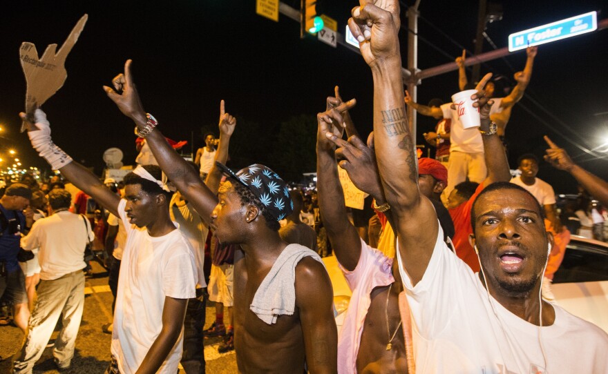 Protesters march Wednesday near the convenience store in Baton Rouge, La., where Alton Sterling was shot and killed.