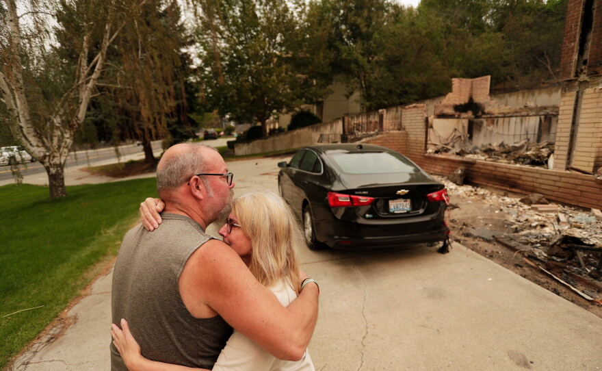 Allen Sather and his wife Kimberley embrace at the duplex they rent on W. Indian Trail Rd. after it burned in a wildfire in Spokane, Wash., Sunday, Aug. 2, 2026.