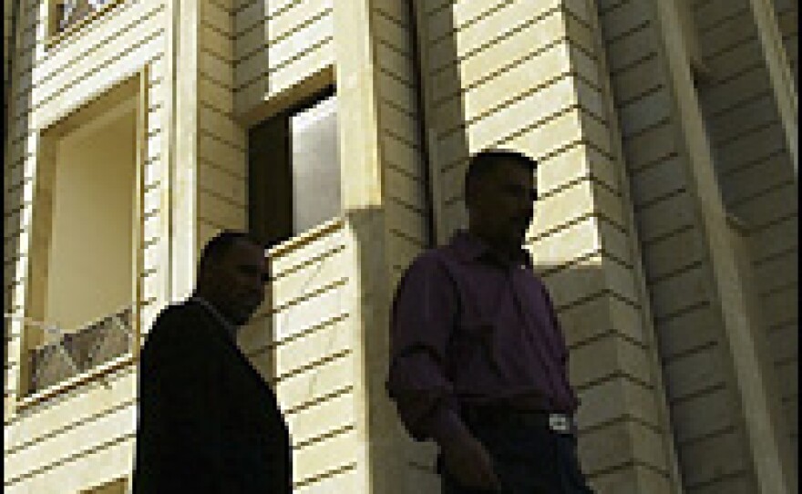 Iraqis are seen in front of the Iraqi Higher Education building where up to 150 government employees and visitors were kidnapped on Tuesday in Baghdad.