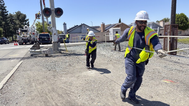 An AT&T crew installs a new cable at a railroad crossing in Hayward, Calif., after the segment got cut down by suspected copper wire thieves.