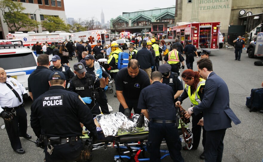 First responders treat injured passengers after a New Jersey Transit train crashed into the platform at Hoboken Terminal during morning rush hour on Thursday.