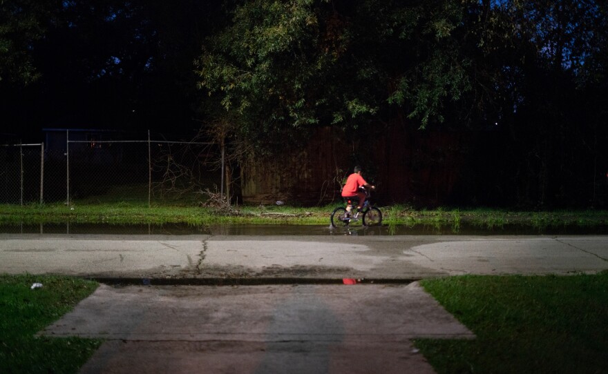 A boy rides his bike through still water after a thunderstorm in the Lakewood area of East Houston, which flooded during Hurricane Harvey.