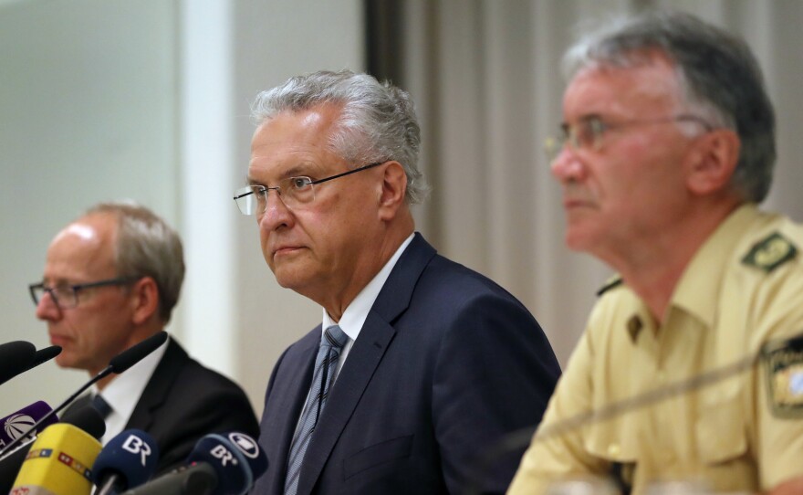 Bavarian Interior Minister Joachim Herrmann (center), briefs the media in Ansbach, Germany on Monday. Bavaria's top security official says a man who blew himself up after being turned away from an open-air music festival in Ansbach was a 27-year-old Syrian who had been denied asylum.