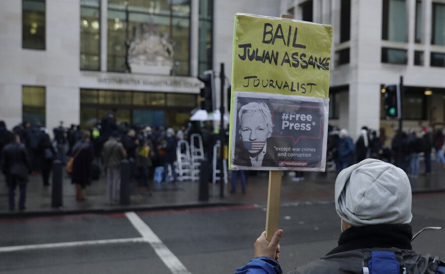 A Julian Assange supporter holds up a placard outside Westminster Magistrates Court, the site of his bail hearing, in London on Wednesday.