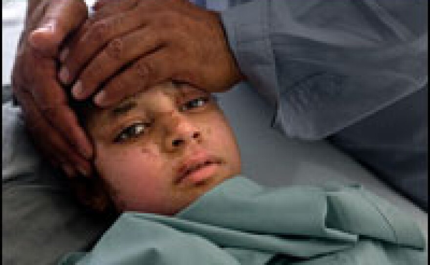 Tallah, 12, is soothed by her father Saeed Barakat in the burn unit of Herat Regional Hospital on May 10 in Herat, Afghanistan. Tallah also had a compound fracture in her leg.