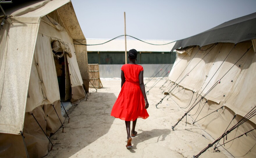 A woman walks between two of the tents that house the hospital wards. Most of the camp's residents are women and children.