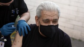 Edward Muro gets a shot of Pfizer's COVID-19 vaccine at Families Together of Orange County Community Health Center, Friday, Feb. 26, 2021, in Tustin, Calif.