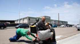 Chris Von Kroog gets help from a friend to push his mobility scooter towards his storage unit after the battery died overnight, San Diego, June 3, 2022.