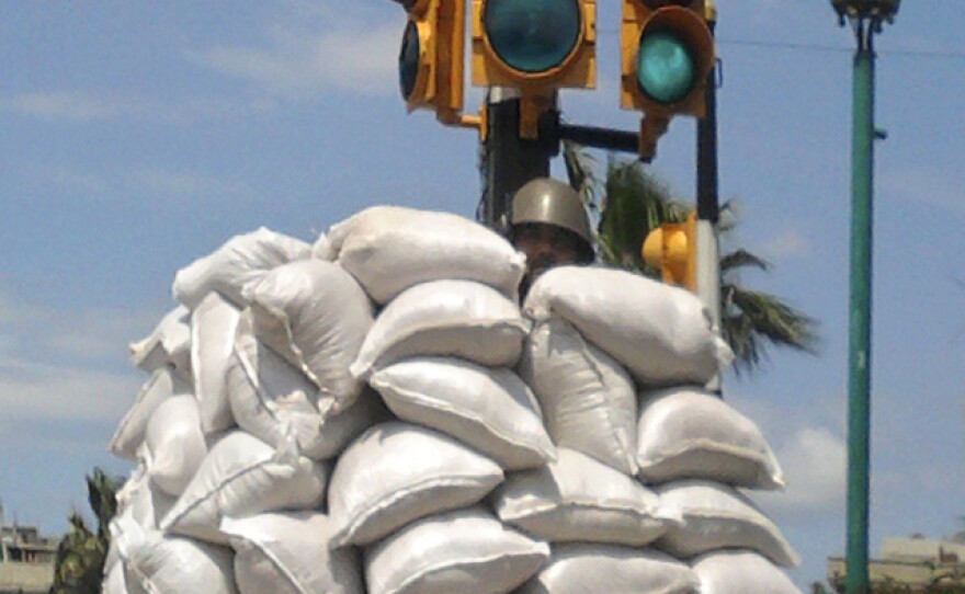 A Syrian soldier hid behind a sand bag barricade in the central city of Homs on Friday.