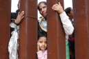 A mother and daughter await volunteer assistance while stuck in a makeshift camp at the U.S.-Mexico border.