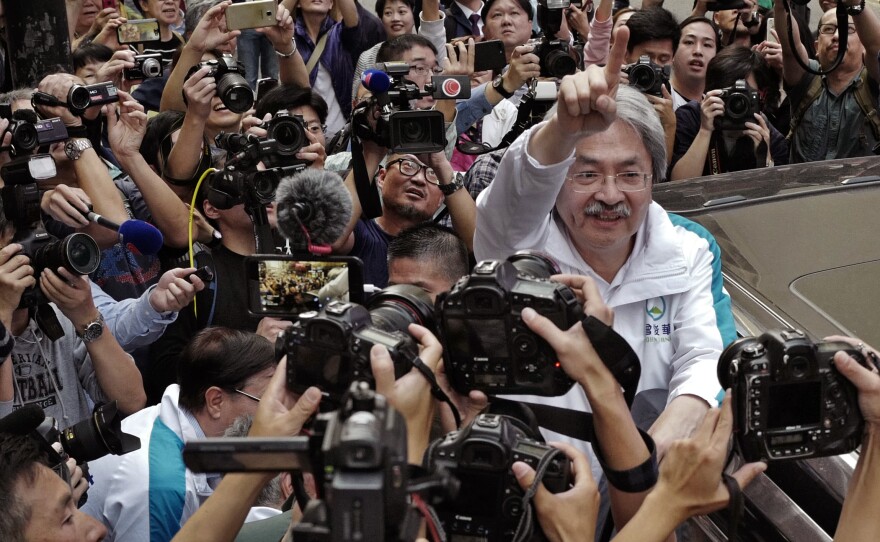 Chief Executive candidate John Tsang waves to supporters in Hong Kong on Friday. Nearly all public opinion polls show he is the most popular candidate and would likely win if there were to be a citywide vote.