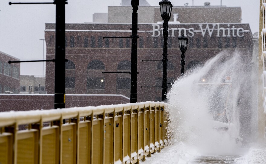 A vehicle clears snow from the pedestrian sidewalk over the Andy Warhol Bridge, Downtown Pittsburgh, Monday, Jan. 17, 2022.