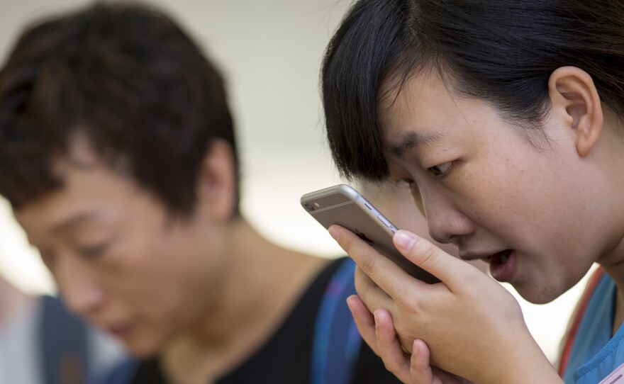 A customer tries the Siri voice recognition function on an Apple iPhone 6 Plus in Hong Kong.