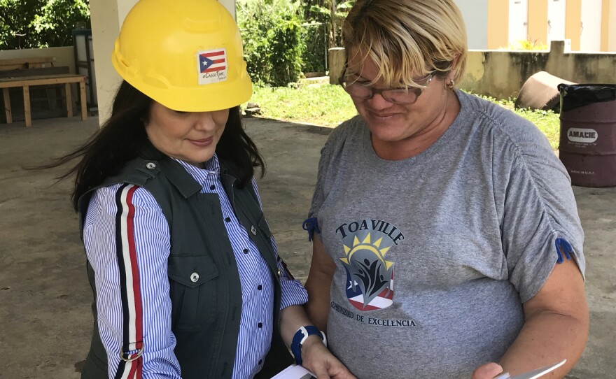 Architect Astrid Díaz (left) talks with Toaville community leader Yarilin Colón about damaged homes in the community.