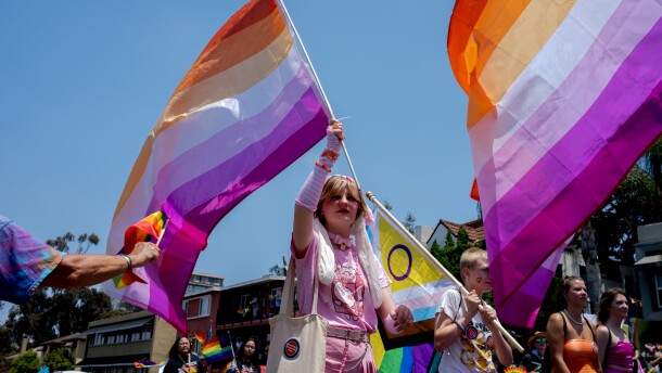 A San Diego Pride Parade goer waves the lesbian Pride flag, July 16, 2022.
