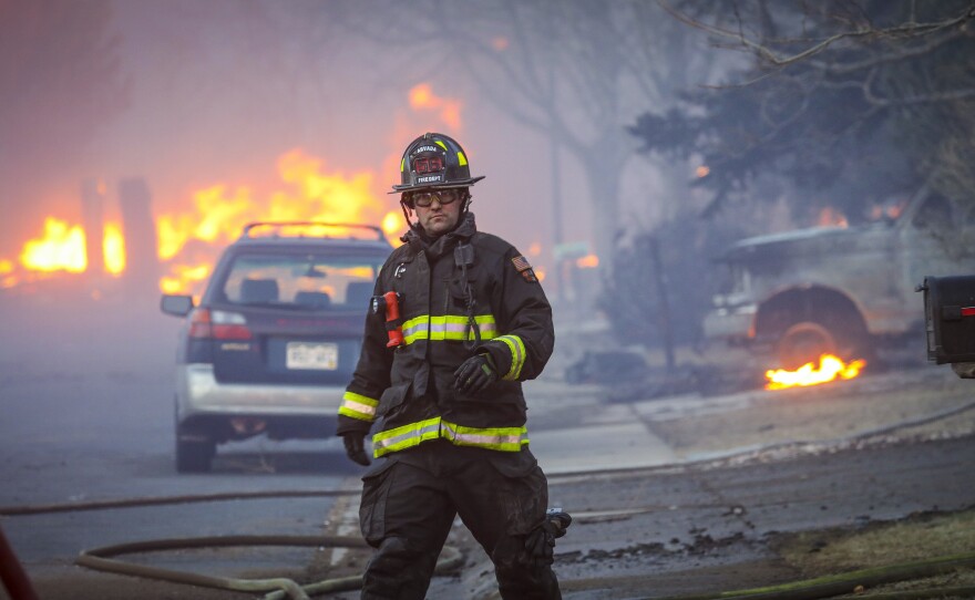 Dec. 30: Louisville, Co. — An Arvada firefighter walks back to the firetruck as a fast moving wildfire swept through the area in the Centennial Heights neighborhood.