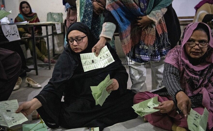 Pakistani election workers sort ballot papers at the start of the vote count in Thursday's general elections, at a polling station in Lahore, Feb. 8.