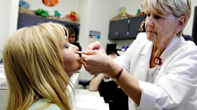 Nurse Gail Symanik is given the nasal mist swine flu vaccine by nurse practitioner Judy Gallob at a medical center in Phoenix in early October.