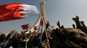 Bahraini protesters wave the national flag and chant slogans as they gather Wednesday at Pearl Square in the capital city of Manama.