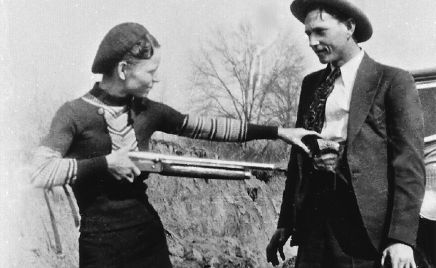 Bonnie Parker and Clyde Barrow, the most famous outlaw couple in U.S. history, posing together in front of car, 1933. Bonnie and Clyde had been on a year-long crime spree, leaving a trail of dead bodies in their wake, yet were little more than a local curiosity until photos of the couple were discovered at a hastily abandoned hideout in 1933.