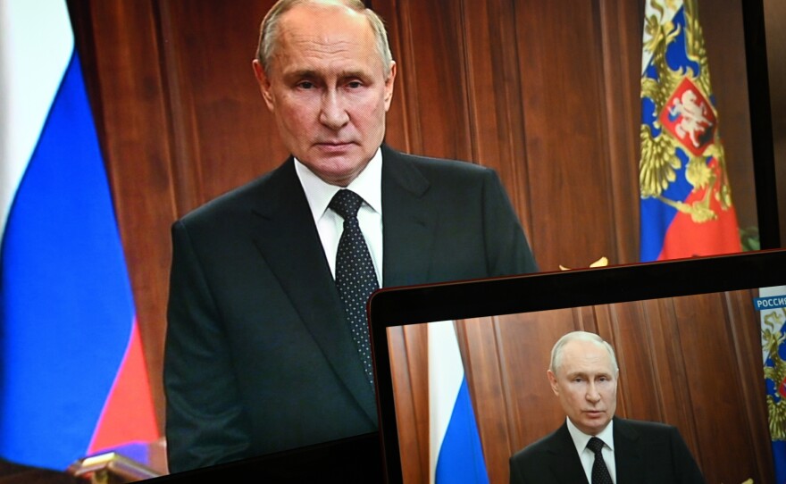 Russian President Vladimir Putin is seen on monitors as he addresses the nation on Saturday after Yevgeny Prigozhin, the owner of the Wagner Group military company, called for armed rebellion.