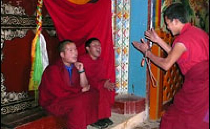 Young monks debate inside Songzanling monastery. One monk conceded that the hordes of visitors reduce the amount of time the monks spend studying.