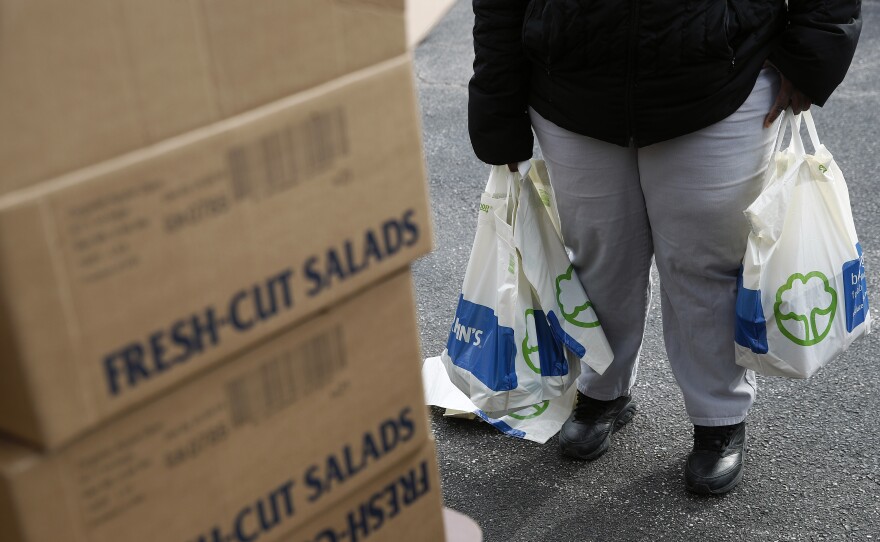 An FDA contract worker collects food and supplies from a food pantry in Baltimore. In the face of a Trump administration proposal that could cause 3 million people to lose federal food assistance, mayors from 70 cities are pushing back.
