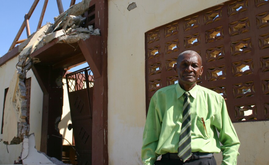 Church leader Nerjuste Louis Sony stands in front of his church, left roofless by the hurricane.