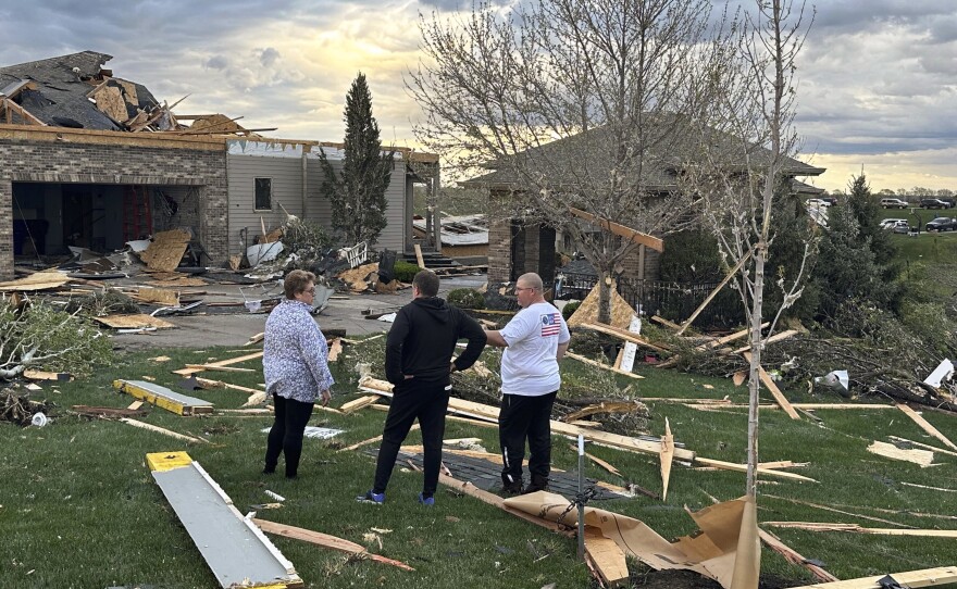 Homeowners in Bennington, Neb., assess the damage after a tornado passed through their neighborhood northwest of Omaha on Friday.