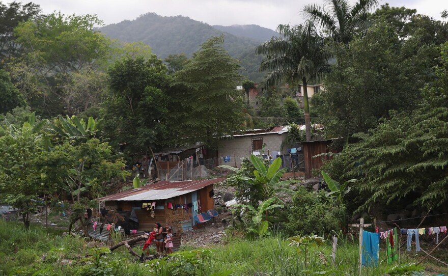 Families live by a creek in an impoverished neighborhood in San Pedro Sula, Honduras.