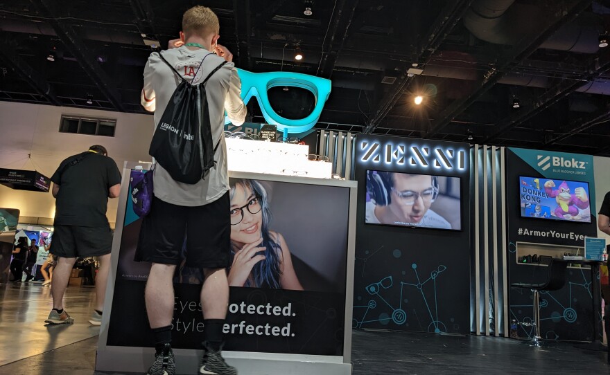 A TwitchCon attendee trying glasses designed to reduce eyestrain from staring at computer screens too long, Oct. 8, 2022.