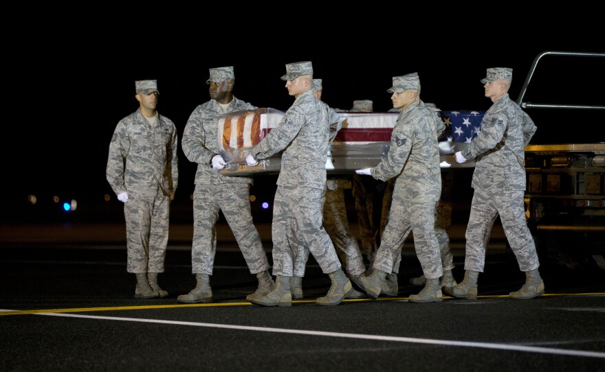 An Air Force team carries the transfer case with the remains of Maj. Phyllis J. Pelky, on Tuesday at Dover Air Force Base, Del. Pelky, 45, was killed two days earlier in a helicopter crash in Afghanistan. Though the U.S. formally ended its combat role in Afghanistan last year, 25 Americans, including military personnel and civilians, have been killed there this year.