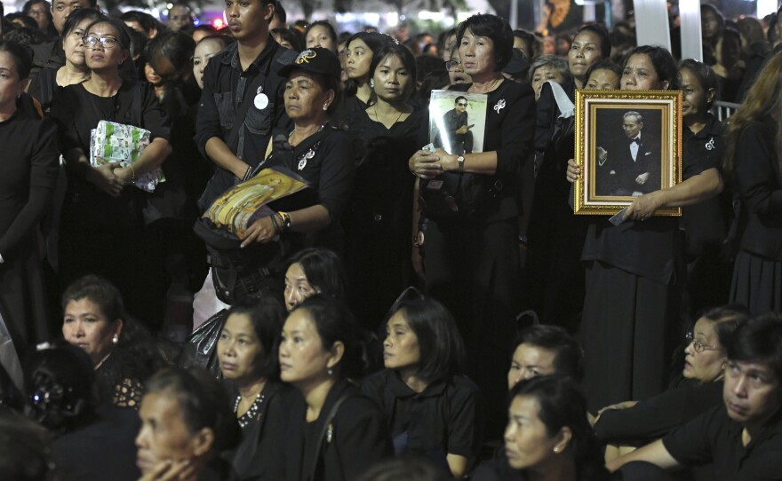 Thai mourners holding portraits of the late King Bhumibol Adulyadej line up to take part in the Royal Cremation ceremony in Bangkok, on Wednesday.