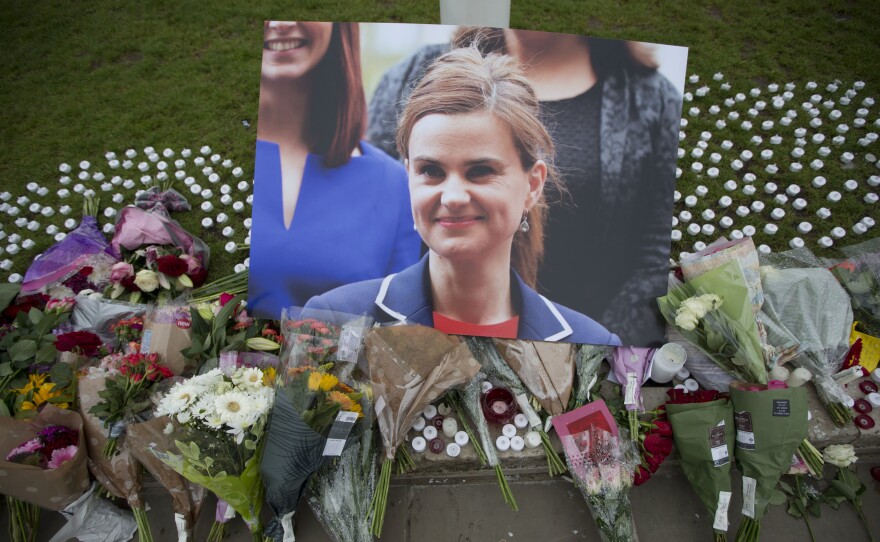 An image and floral tributes for Jo Cox, lay on Parliament Square, outside the House of Parliament in London on Friday. The 41-year-old British Member of Parliament was fatally injured in an attack on Thursday in northern England.