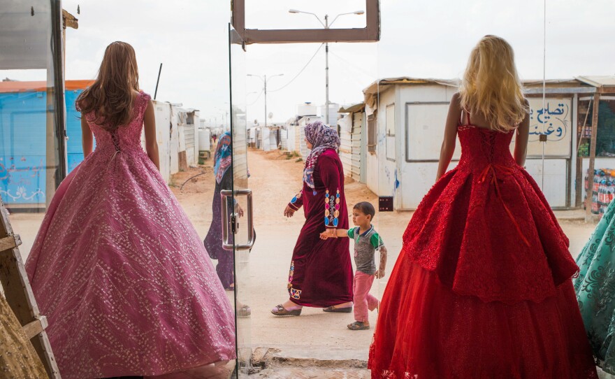 Wedding dresses come in bold hues at Salon Al Fardous — Paradise Salon. The rent-a-gown shop looks out on the temporary housing and makeshift stores in the Zaatari refugee camp in Jordan.