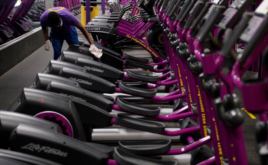 A Planet Fitness Inc. employee cleans gym equipment before the location's reopening on March 15, after being closed due to Covid-19 in Inglewood, California.