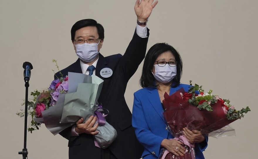 John Lee, former No. 2 official in Hong Kong and the only candidate for the city's top job, celebrates with his wife after declaring his victory in the chief executive election of Hong Kong in Hong Kong, Sunday, May 8, 2022.