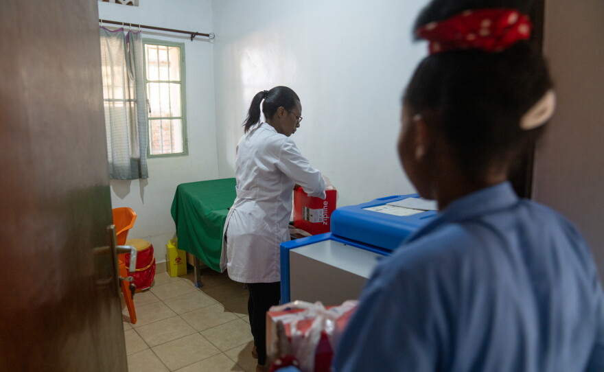 At a health post in the remote town of Ituze, head nurse Rosaline Uwera unpacks a shipment of medicine and puts it away in a solar refrigerator at a health center.