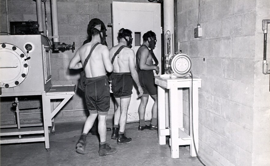 Three test subjects enter a gas chamber, which will fill with mustard gas, as part of the military's secret chemical warfare testing in March 1945.