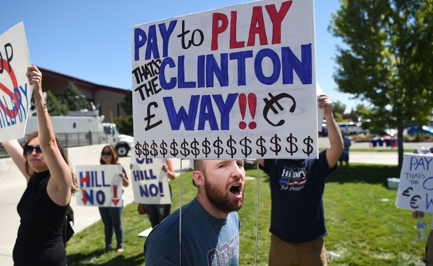 Protesters shout as people wait to enter a Hillary Clinton campaign event last month in Nevada. Donald Trump is calling for a special prosecutor to investigate allegations of pay-to-play by Clinton, but the history of independent counsels and special prosecutors suggests they don't always remove politics from the process.