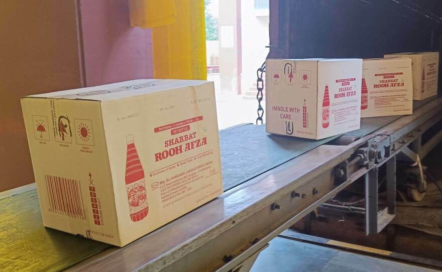 Cartons of Rooh Afza bottles move up a conveyor belt and into a truck, ready to be dispatched from Hamdard's factory near Delhi.