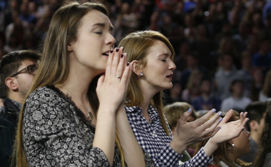 Students at Liberty University sing and pray as they wait for a speech by Donald Trump.