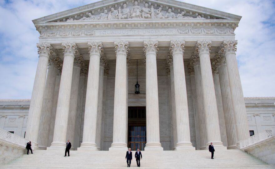 Chief Justice John Roberts (second from right) and Justice Neil Gorsuch (center) walk down the steps of the Supreme Court in Washington, D.C., last week. The court is wrapping up its term, with a handful of consequential cases decided on Monday.