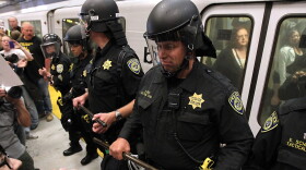 Bay Area Rapid Transit (BART) police keep back demonstrators that are trying to keep a train from leaving the Civic Center station on August 15, 2011 in San Francisco, California.