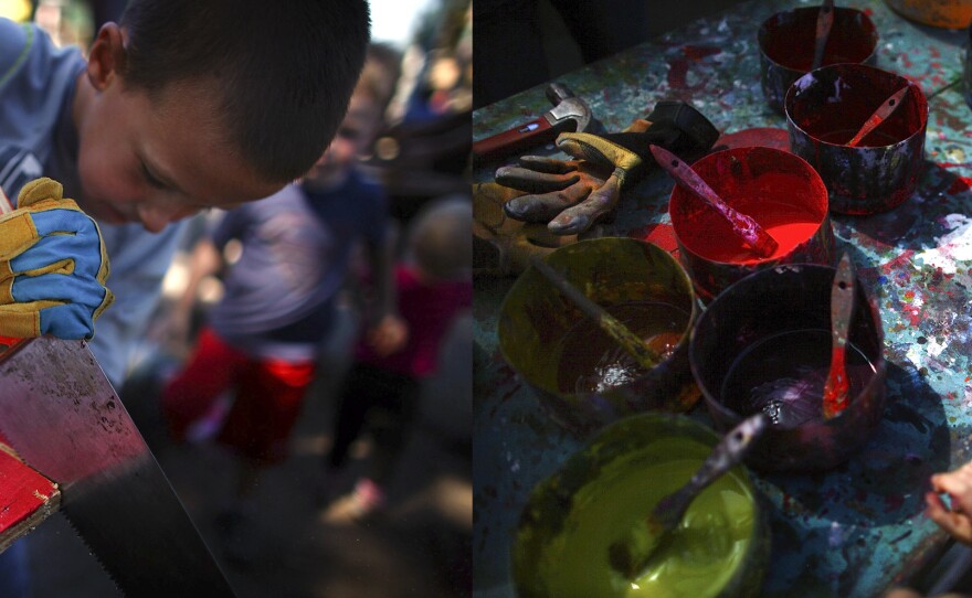 Tyler Swenson, 7, saws a board that he has already painted bright red.
