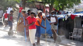 Women sweep the street in an impoverished area in Port-au-Prince that was devastated by the Jan. 12 earthquake. The women are being paid $3-$5 a day to do this kind of work by the aid group Oxfam.