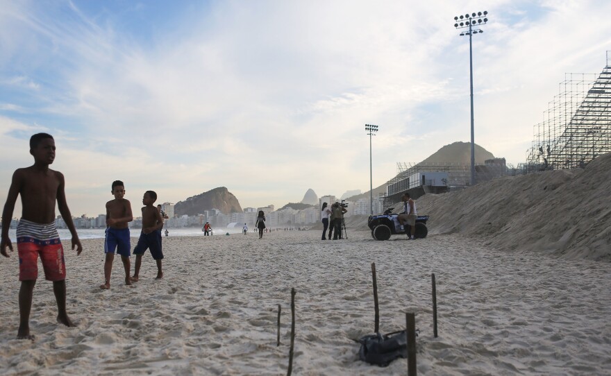 Young beachgoers walk near a body part covered in a plastic bag, which was discovered on Rio's Copacabana Beach near the Olympic beach volleyball venue on Wednesday. The Rio 2016 Olympic Games begin August 5.